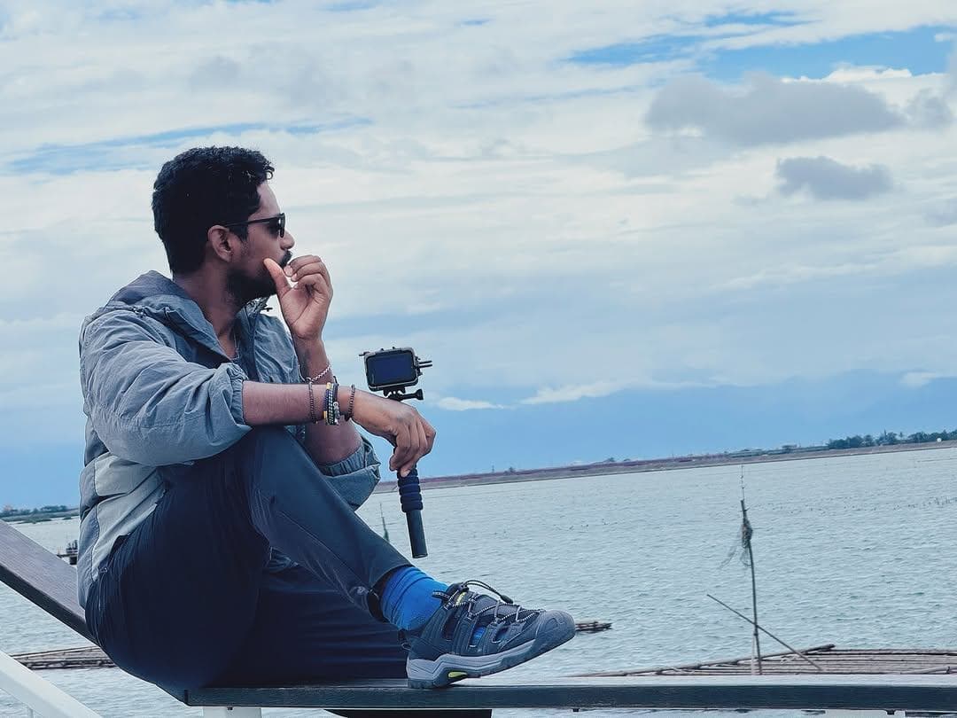 Ranjith sitting quietly on a dock, looking out over open water